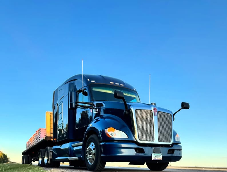 Tractor-trailer with step- deck flatbed, loaded, on the road